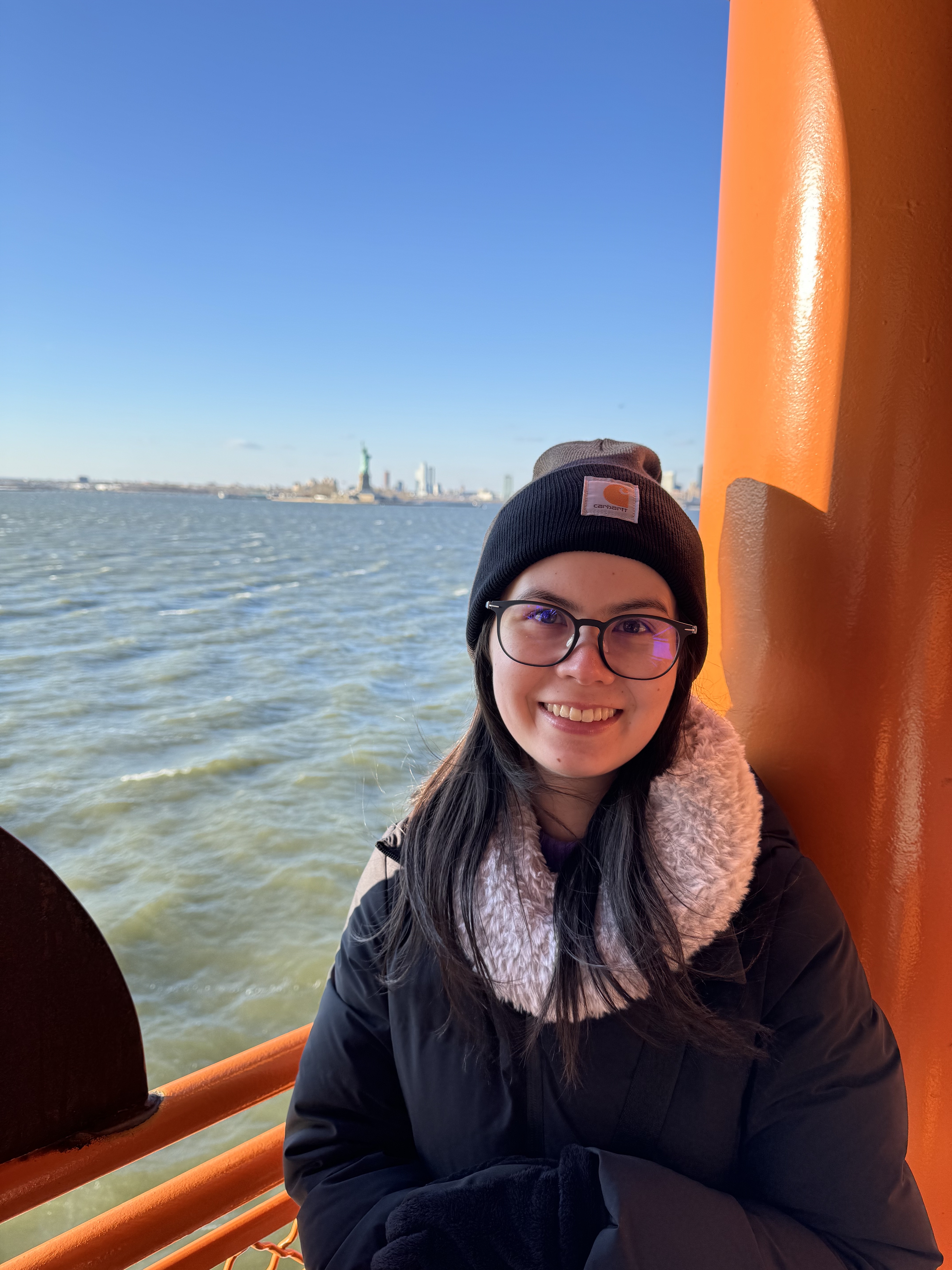 Portrait of Gen on a ferry with the Statue of Liberty in the background